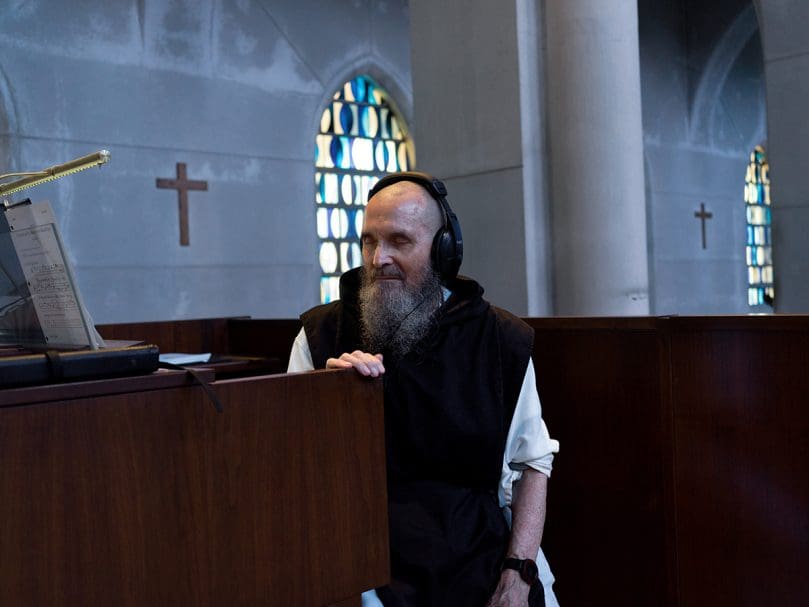 Brother Gerard Gross,  seated at the organ, readies for vespers in the Abbey Church sanctuary at the Monastery of the Holy Spirit. Photo by Johnathon Kelso