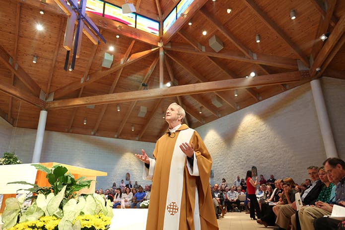 Addressing the congregation as he walks around Church of the Transfiguration, Msgr. Patrick Bishop delivers his farewell homily after 25 years as the Marietta parish’s pastor. Msgr. Bishop has also been a priest for 40 years. Photo By Michael Alexander