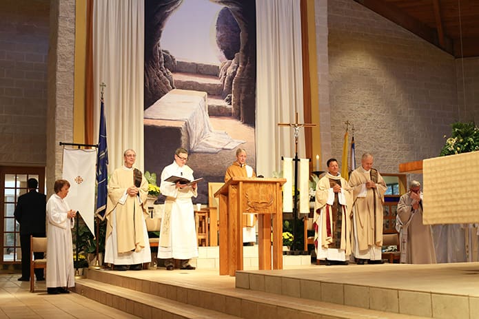 ‘Msgr. Patrick Bishop, center, is joined on the altar by (l-r) Father Edward O'Connor, the first pastor he served under, Deacon Tom Coffey of Transfiguration Church, Father Fernando Molina Restrepo, Transfiguration’s incoming pastor, and Father Richard Morrow, his good friend and mentor. Photo By Michael Alexander