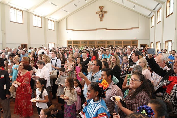 Parishioners gather in the old worship space, which was converted to the new parish hall, to watch ethnic dancers perform during a reception. The parish hall is also equipped with a new full commercial kitchen. Photo By Michael Alexander