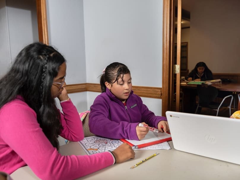 Tutor Geethika Janaki, left, helps student Victoria Morales with her homework during a after-school program supported by Next Generation Focus, a nonprofit which helps to tutor and mentor students in the greater Atlanta area. St. Brendan the Navigator Church is hosting the program. Photo by Johnathon Kelso