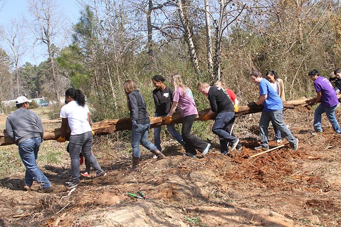 Back in March University of Georgia students remove wooded debris from the grounds of Oasis CatÃ³lico Santa Rafaela, which occupies space inside the Pinewood Estates North mobile home community, Athens. Photo By Michael Alexander