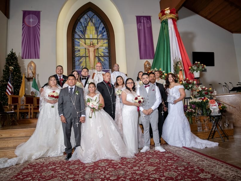 Cardinal Álvaro Leonel Ramazzini Imeri, Bishop of Huehuetenango, and Father Cyriac Mattathilanickal, MS, pose with those who were married during a community wedding at St. Oliver Plunkett Church on the feast of Our Lady of Guadalupe. Photo by Johnathon Kelso