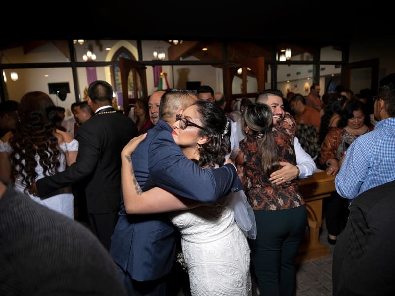 Gabriel Jimenez hugs friends and family following a community wedding held at St. Oliver Plunkett Church on the feast of Our Lady of Guadalupe. Photo by Johnathon Kelso