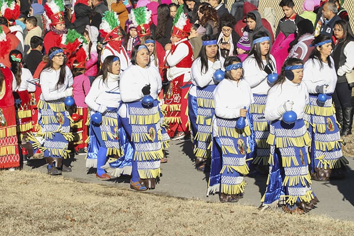 Before the procession for the Our Lady of Guadalupe festival at Heritage Point Park in Dalton gets underway, dancers from Saint Toribio Romo Mission in Chatsworth try to stay warm under frigid conditions by performing among the crowd. Photo By Michael Alexander