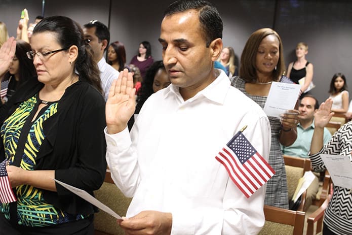 Regmi takes the oath of allegiance to become a United States citizen in a ceremony with 162 other people from 63 different countries at the U.S. Citizenship and Immigration Services office in Atlanta. Photo By Michael Alexander