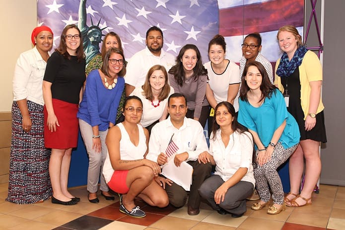 Pasupati Regmi, squatting center, is joined by his wife Bhakti, right, his cousin Chhali Subedi, left, and his Catholic Charities Atlanta colleagues for a photo following his citizenship ceremony. Photo By Michael Alexander