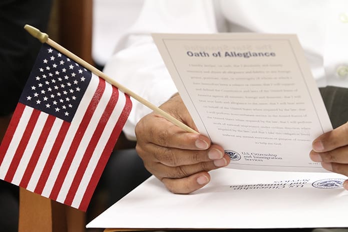 Pasupati Regmi, a native of Bhutan, looks over the U.S. citizenship program and material that was presented to him when he entered the auditorium where the citizenship ceremony would take place Aug. 29. Photo By Michael Alexander
