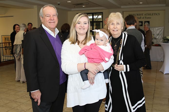 As she holds her eight-month-old daughter, Alexis, Amanda Blanford Sessions, center, stands between John and Arlene Gannon, one of the founding families of Pinecrest Academy. Sessions is a former student and she currently has a four-year-old daughter in the school’s pre-kindergarten class. Photo By Michael Alexander