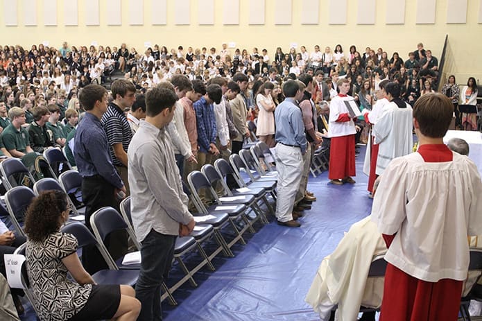 Bishop Luis Zarama extends a special blessing to the standing members of the 2014 Pinecrest Academy senior class before the Mass concludes. Photo By Michael Alexander