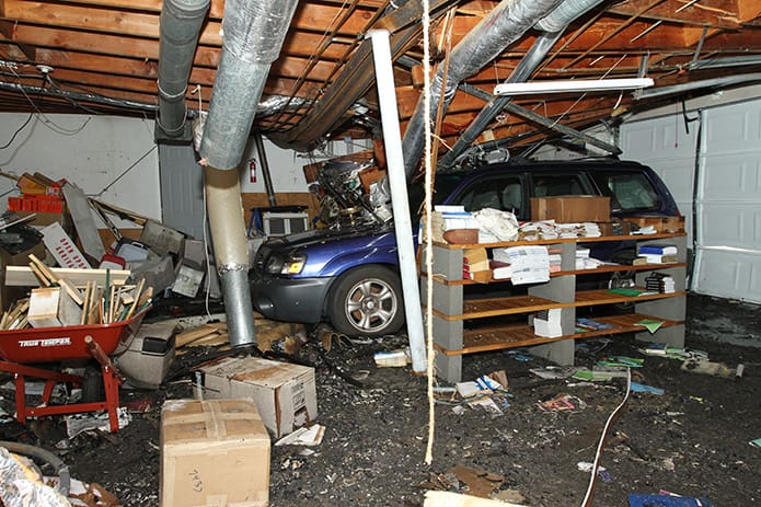 Barbara Keller’s vehicle was parked in the garage the evening of the crash. The flooring, pipes and metal beam above the car collapsed under the impact of the plane crash. At this point the garage and house were structurally unsafe for anyone to enter. Photo By Michael Alexander