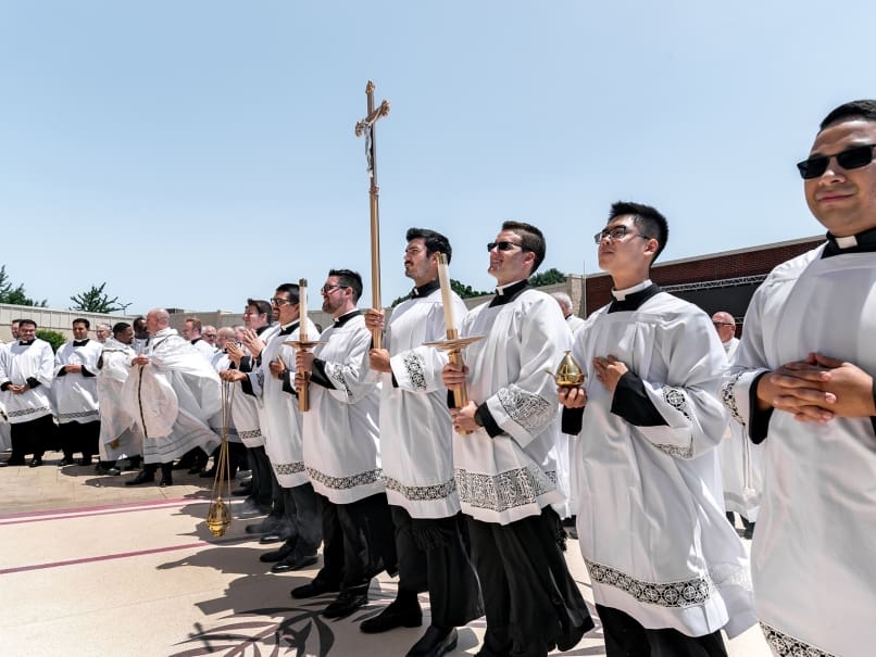 Seminarians and clergy line up outside to congratulate the newly ordained priests at Holy Vietnamese Martyrs Church. Photo by Johnathon Kelso