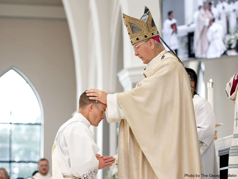 Archbishop Gregory John Hartmayer, OFM Conv., lays hands on Deacon Colin Patrick during the Mass of ordination to the priesthood at Holy Vietnamese Martyrs Church. Photo by Johnathon Kelso