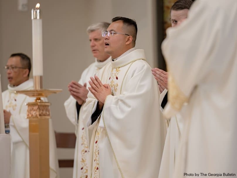 Father Joseph Nguyen prays at the altar during the eucharistic liturgy at Holy Vietnamese Martyrs Church. Photo by Johnathon Kelso