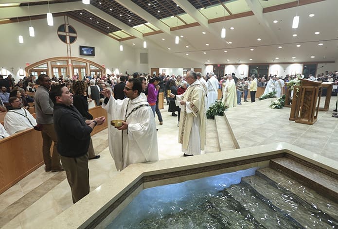 Father José Luis Hernández-Ayala, foreground, second from left, pastor of St. Mark Church in Clarkesville, distributes Holy Communion to the congregation. Early in his priesthood he served as a Prince of Peace Church parochial vicar. Photo By Michael Alexander