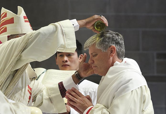 Archbishop Wilton D. Gregory pours sacred chrism on the head of Bishop Bernard E. (Ned) Shlesinger III during his July 19 episcopal ordination in the Atlanta Archdiocese. Photo By Michael Alexander