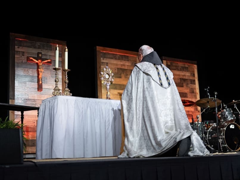 Archbishop Gregory J. Hartmayer, OFM Conv., kneels in adoration before the Blessed Sacrament during Rescue Atlanta at the Cobb Galleria Centre. Photo by Johnathon Kelso