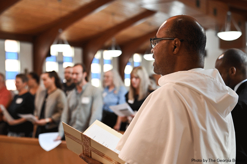 Father Jeffrey Ott, OP, pastor of Our Lady of Lourdes Church, sings during the prayer service to kick off the National Catholic Conference on Restorative Justice. Photo by Julianna Leopold