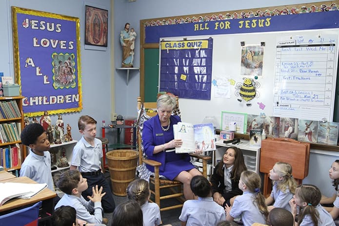 Melody Summers, center, reads Andrea F. Phillips’ book about the apparitions of Our Lady of Fatima, “Jacinta’s Story,” to her fourth-grade students at St. Thomas More School, Decatur. Miss Summers has a great devotion for the Blessed Mother and she calls St. Anthony her favorite saint. Miss Summers was baptized on his June 13 feast day. Photo By Michael Alexander
