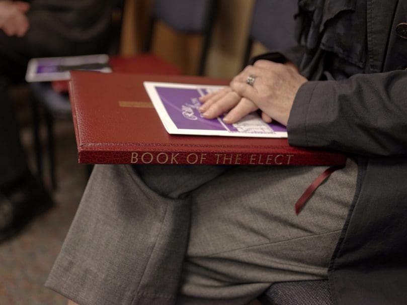 A parish RCIA director holds the Book of the Elect before the Rite of Election begins at St. Catherine of Siena Church. Photo by Johnathon Kelso