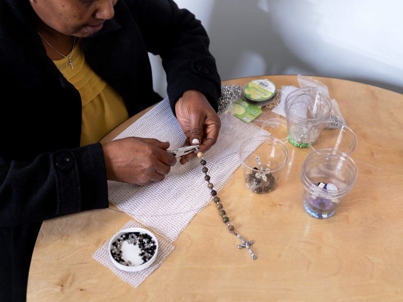 Instructor Almaz Tecelu of Rosary Makers of America pieces together a  rosary. Photo by Johnathon Kelso
