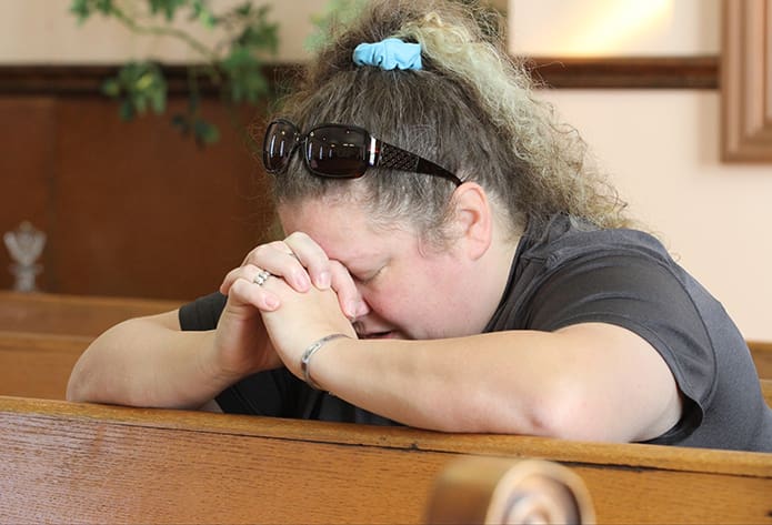 Belinda Hale joins other members of the congregation in praying before the 11:30 Mass. They usually pray the rosary, but during the Year of Mercy they’ve prayed the Divine Mercy Chaplet. Photo By Michael Alexander