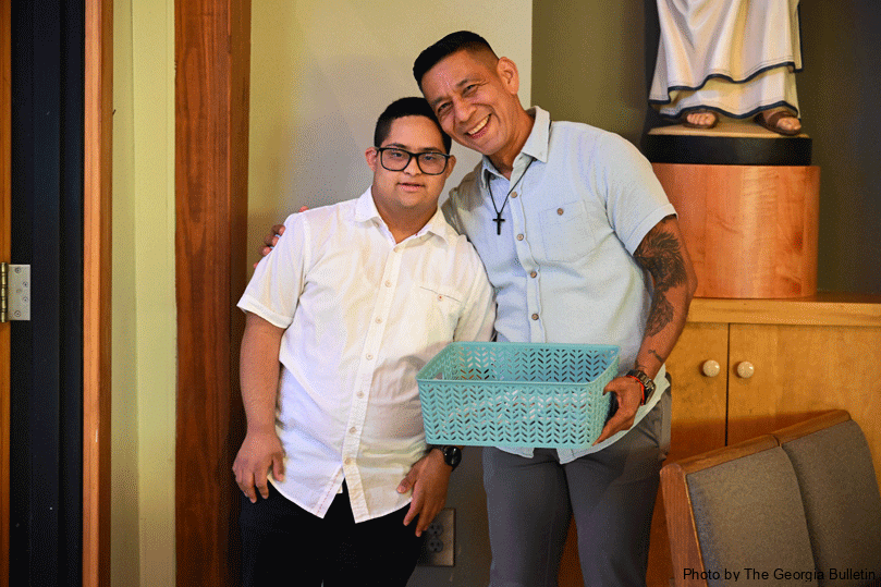 Andres David Mendoza, left,  and Jorge Mejia, right, stand together at the back of the church handing out programs and welcoming parishioners to the sensory Mass in Lithia Springs.  Photo by Julianna Leopold
