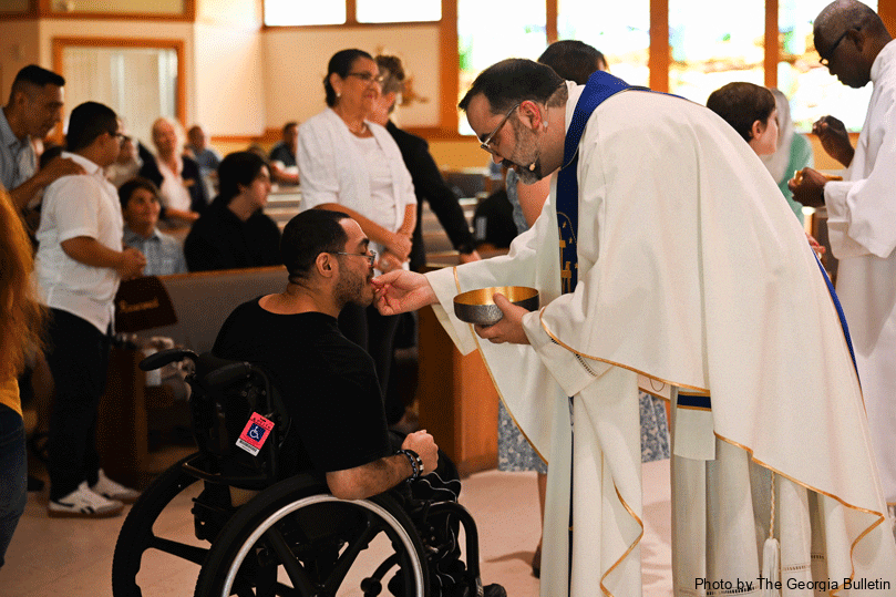 Leo Milano receives communion from Father Jack Knight, pastor of St. John Vianney Church during the first sensory Mass on Sept. 15.  Photo by Julianna Leopold