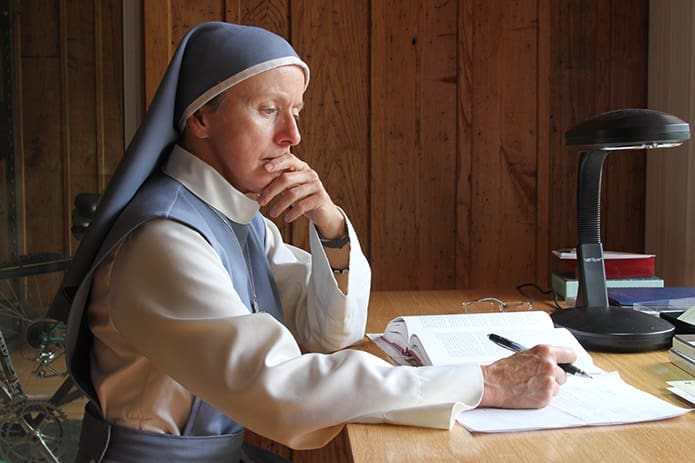 Sister Mary Beatrice Raphael sits at the desk where she reads and attends to matters of business or correspondence. Photo By Michael Alexander