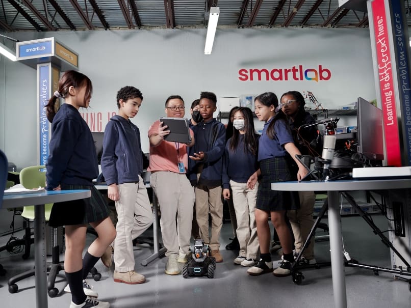 Smartlab Facilitator Phu Vu teaches a fifth-grade class how to operate one of their robots at St. Peter Claver Regional School. The new lab space helps introduce students to a different set of skills. Photo by Johnathon Kelso