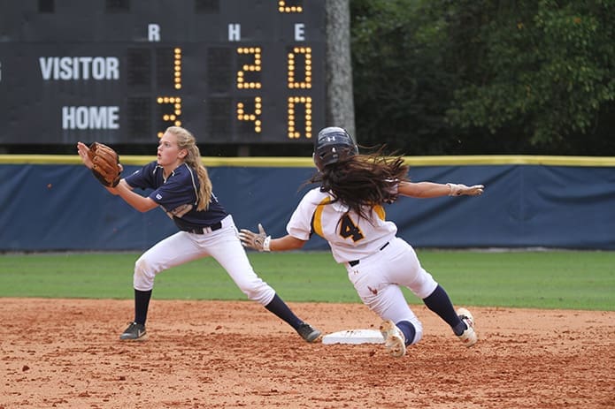 St. Pius X shortstop Grace Bartles, left, waits for the ball to reach her glove as Marist School junior Gabriella Teran (#4) slides into second base during the second inning. Photo By Michael Alexander