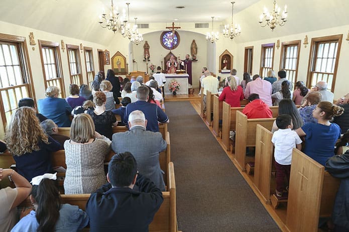 St. Bernadette Church, Cedartown, is so small and the aisle is so narrow that one communion line is formed, and people go up one side of the church at a time. There are 18 pews, each holding four to six persons. Photo By Michael Alexander