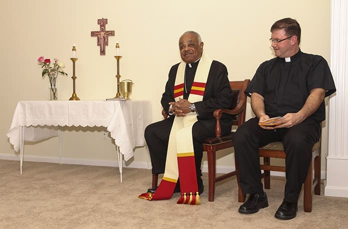 Archbishop Wilton D. Gregory, left, gives some brief remarks about the St. Charles Borromeo House and how its eight seminarian occupants should conduct themselves. Looking on is Father Tim Hepburn, archdiocesan vocations director, who also resides at the house. Photo By Michael Alexander
