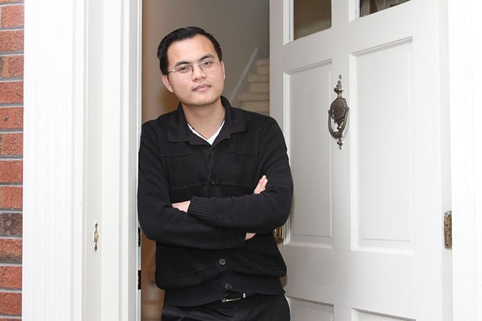 Anh Joseph Nguyen stands at the front entrance to one of the St. Charles Borromeo House units. The 22-year-old native of Vietnam formerly worked in a New Jersey nail salon. Nguyen entered formation as a seminarian for the Archdiocese of Atlanta this fall. Photo By Michael Alexander