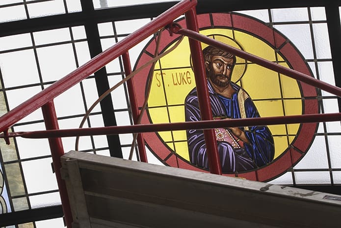 During the reinstallation of the glass panels, scaffolding surrounds the image of St. Luke, one of the Four Evangelists depicted in the refurbished vaulted glass skylight at St. John Chrysostom Melkite Catholic Church . Photo By Michael Alexander