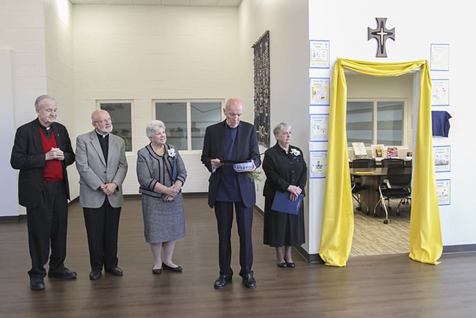 Father John Adamski, second from right, conducts a prayer for the blessing and dedication of the Mercy Conference Room, to his left, at St. John the Evangelist School in Hapeville. Joining him front and center for the occasion are (l-r) Father Richard Morrow, Father Steven Yander and Sisters of Mercy Kathleen Lyons and Sally Condart. Father Adamski served as a parochial vicar in the parish from 1973-1976 when Father Morrow was the pastor. Photo By Michael Alexander