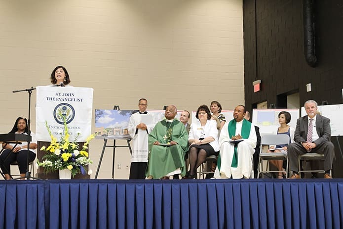 Alex Azzarello, at podium, St. John the Evangelist School development director, expresses her gratitude to everyone who had a hand in making the new Enrichment Center and fine arts wing a reality. Seated on the front row, l-r, are Archbishop Wilton D. Gregory, Diane Starkovich Ph.D., superintendent of schools, Father Michael Onyekuru, pastor of St. John the Evangelist Church, and Hapeville mayor Alan Hallman. Photo By Michael Alexander