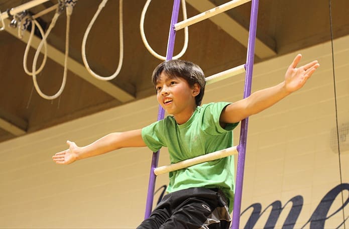 Elijah Peterson, a sixth-grader at St. Jude, practices his aerial act on the ladder. Photo By Michael Alexander