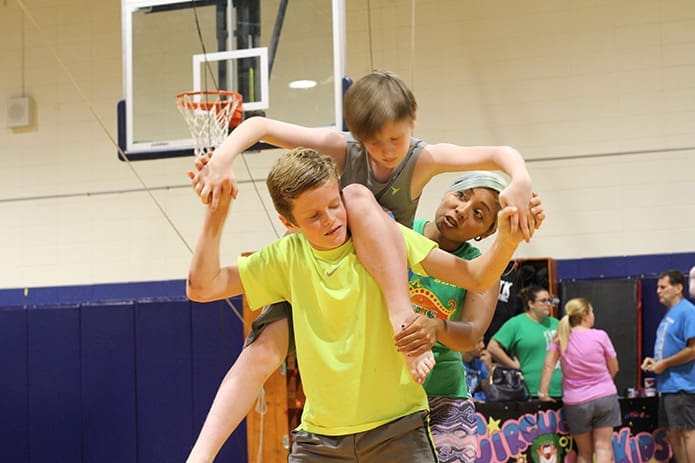 It’s a little touch and go in the beginning as Brendan Wild, top, tries to climb on the shoulders of fellow student Jack McCarthy during their Sept. 8 preparation for the human balancing act. Instructor Alyssa Luna, right, provides assistance to the sixth-graders. Photo By Michael Alexander