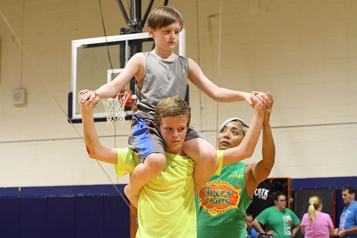 Eventually Brendan Wild successfully climbs on the shoulders of Jack McCarthy with the help of instructor Alyssa Luna, right. Photo By Michael Alexander