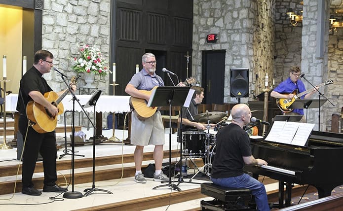 During Praise and Worship for the students at St. Jude the Apostle School, (l-r) Father Tim Hepburn, Chris Fason, Mike Hinton, Ed Bolduc and Jeff Simpson provided the vocals and instrumentation. Fason is the physical education teacher and Simpson is the music teacher at the school. Photo By Michael Alexander