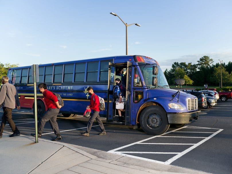 Students step off the bus at St. Mary's Academy in Fayetteville on the first day of school. Photo by Johnathon Kelso