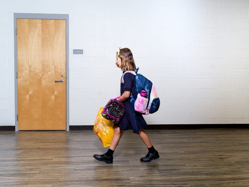 A student walks to class in the halls of St. Mary's Academy in Fayetteville on the first day of school. Photo by Johnathon Kelso