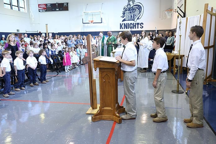 (L-r) Eighth-grader John Lucas Todd leads the Prayers of the Faithful with his fellow classmates Nolan Kelley and Taylor Barnes. Photo By Michael Alexander