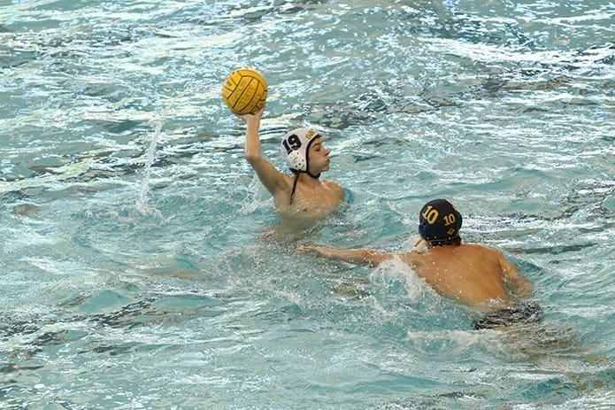 A St. Pius X player holds the ball over his head as he looks for a teammate to pass to during the match against the Wheeler High School Wildcats. Photo By Michael Alexander