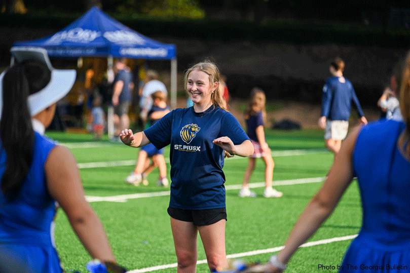 Zoe Leiner smiles as she directs the 23-member band on the field during the middle school fall festival at St. Pius X High School.  Photo by Julianna Leopold
