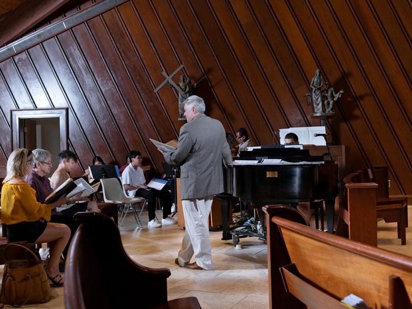 Music Director Eric Alexander rehearses with the choir inside the sanctuary at St. Thomas Aquinas Church before the the 50th anniversary celebration hosted at the parish on June 4th, 2022. Photo by Johnathon Kelso