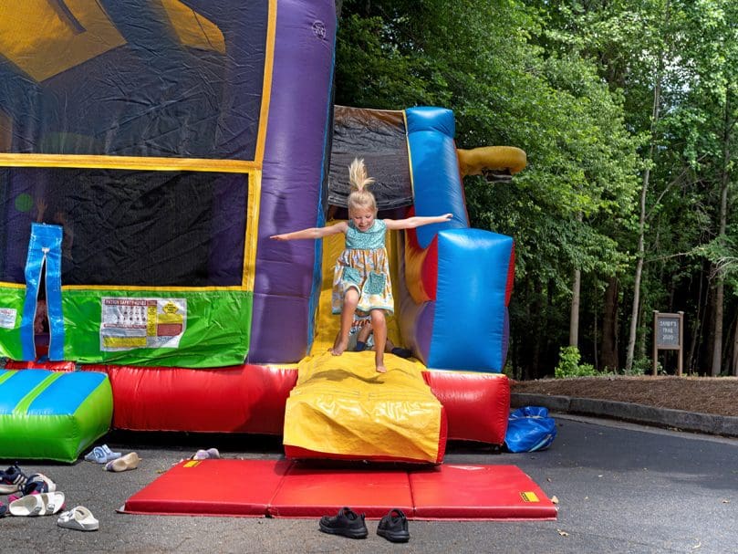A child jumps from a bounce house at St. Thomas Aquinas Church's recent anniversary celebration. Photo by Johnathon Kelso