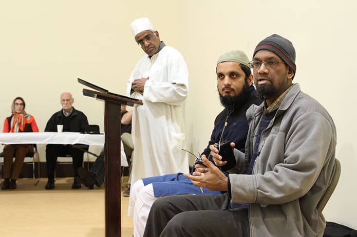 (Foreground to background) Ahmed Ali, a local scholar who teaches adult class at the Islamic Center of North Fulton, and Imam Asad Khan field questions about Islam from St. Thomas Aquinas Church parishioners who visited Dec. 4. The parishioners are part of a 12-week course on the Abrahamic religions at the Alpharetta Catholic church. Standing in the background is the Center’s executive committee president Dr. Moiz Mumtaz, who also participated in the discussion. Photo By Michael Alexander