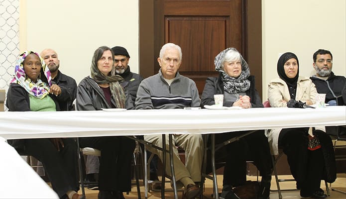 St. Thomas Aquinas Church parishioners (l-r) Ami Sokoyama, Karen Sowa and Bob and Sammie Pfister sit with Sister Rubeena Rafi, education initiatives director for the Islamic Center of North Fulton. Seated behind the table (r-l) are Brother Siraj Abdul Ghaffar, youth director, Rashid Abbasi and Rayhan Qadri. Photo By Michael Alexander